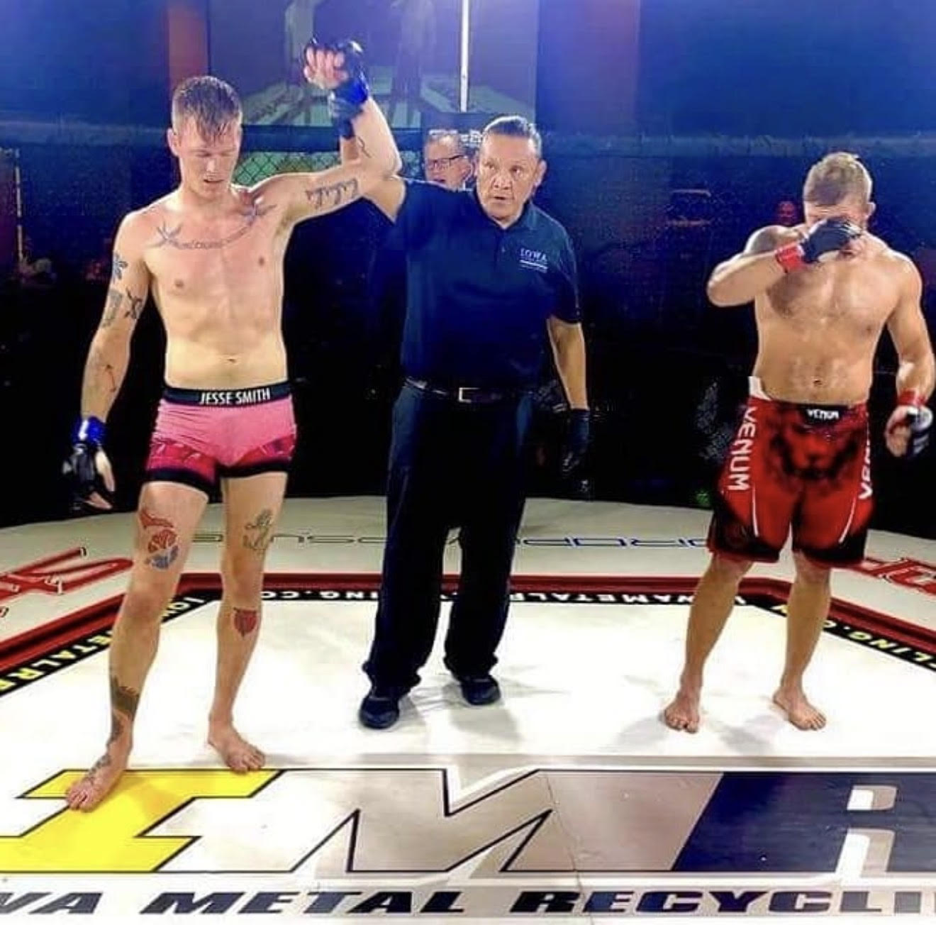 Jesse Smith having his hand raised by the referee after a win in the cage